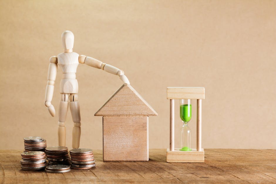 A wooden mannequin figure gently touching the roof of a small wooden house model, surrounded by stacks of silver coins, with an hourglass containing bright green sand positioned to the right, all arra